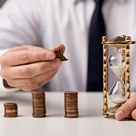 Hands Holding Coins and Sandclock