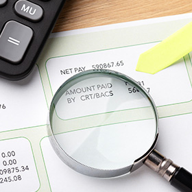 A Magnifying Glass on Top of a Bank Statement